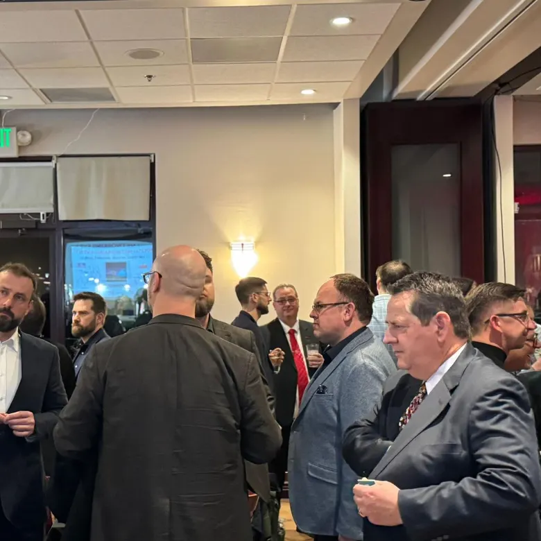 Members and guests in conversation at a crowded VisionariesNV networking reception